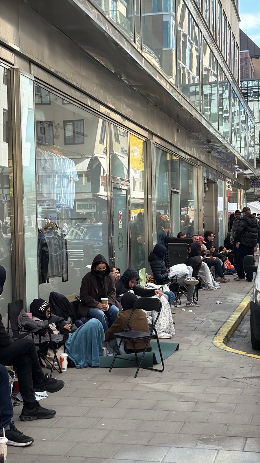 royal pop-kön ringlar längs gatan i stockholm med campingstolar, filtar och liggunderlag