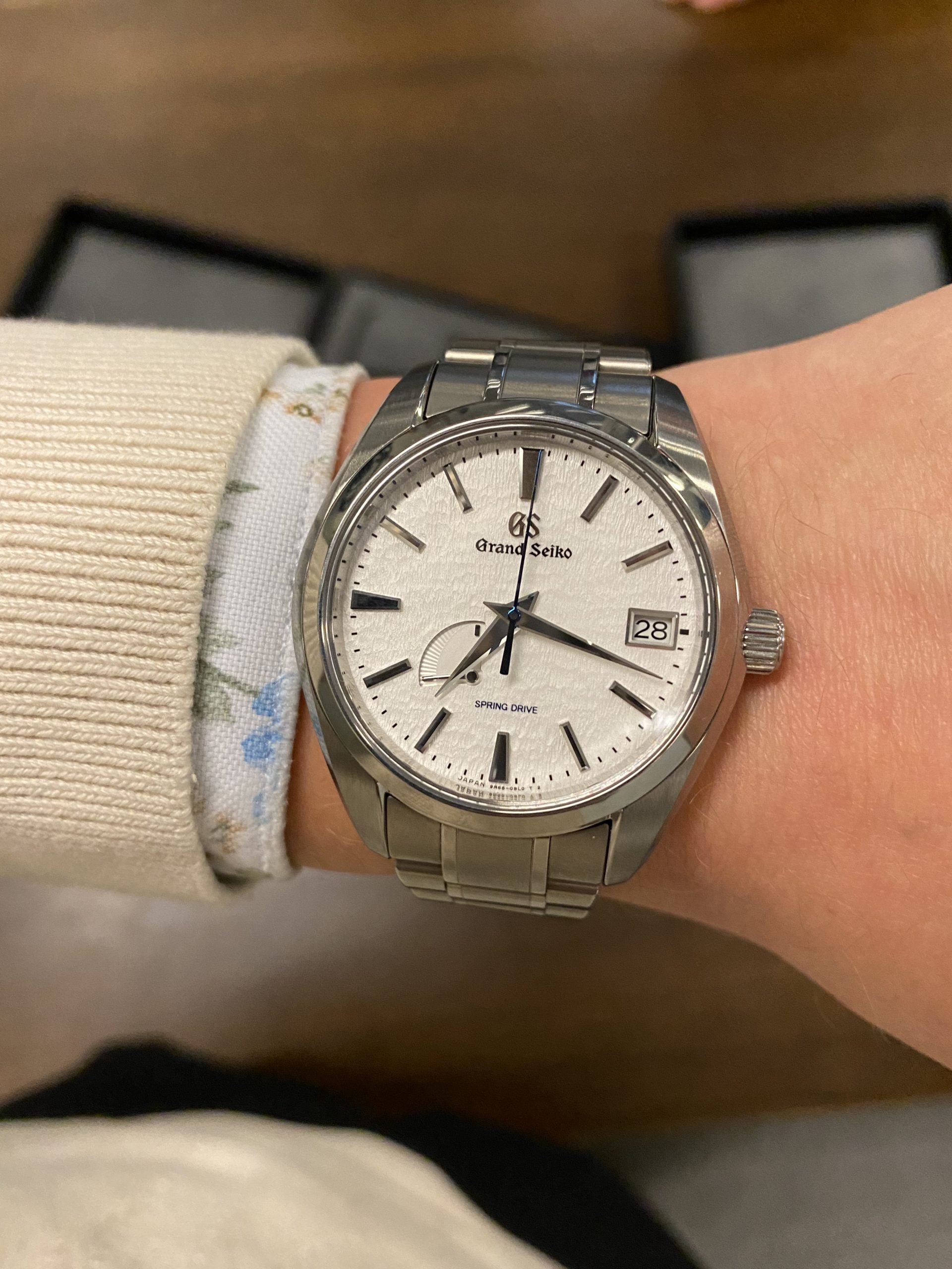 grand seiko spring drive snowflake (sbga211) med texturerad snövit tavla, blå sekundvisare, gångreserv och stållänk – hands-on på handleden