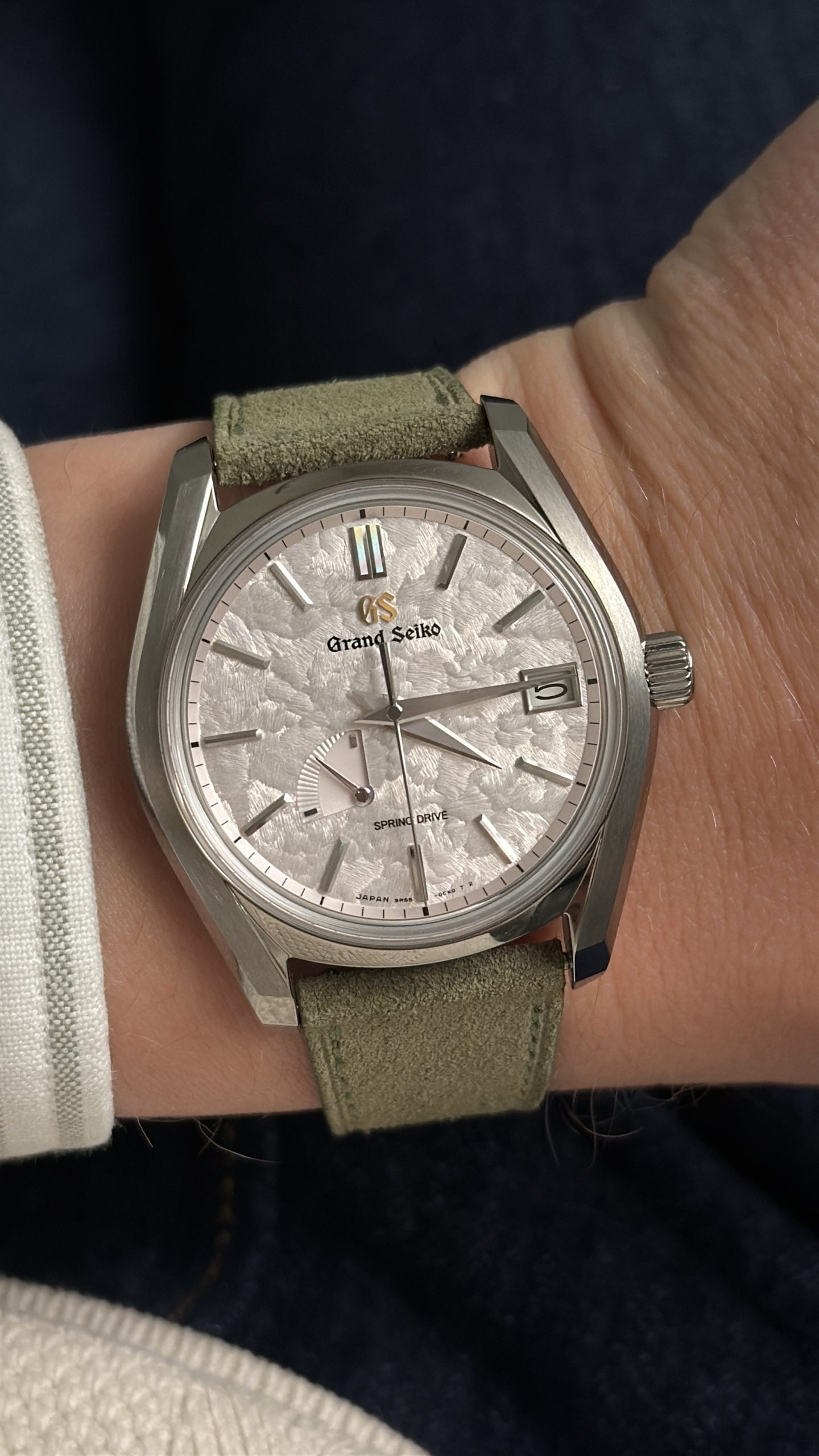 grand seiko spring drive med texturerad silvervit tavla, gångreservvisare och datum på grön mockarem – hands-on på handleden