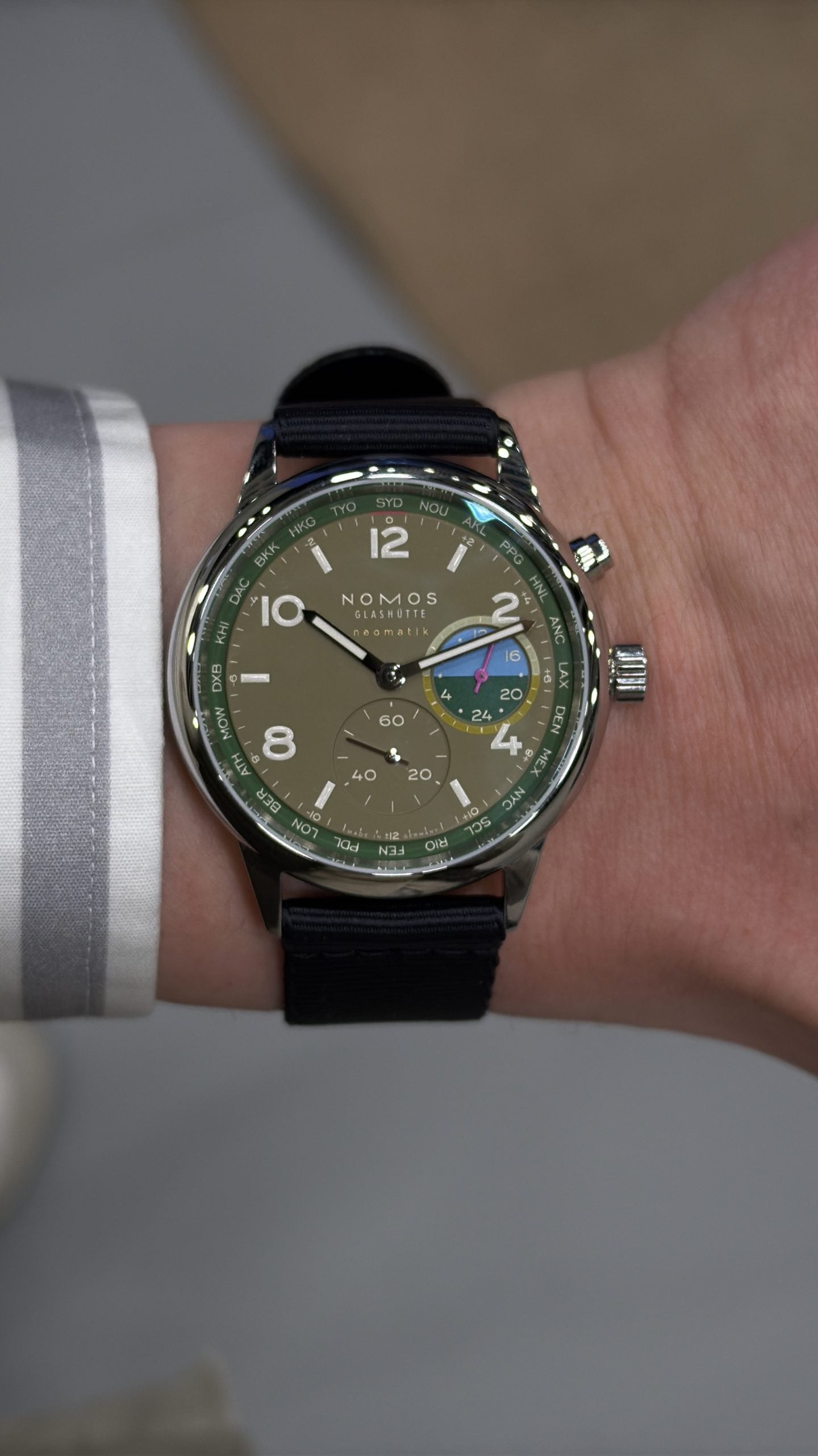 nomos glashütte neomatik med olivgrön tavla, världstids-stadsring och andra tidszon på mörkblå rem – hands-on på handleden