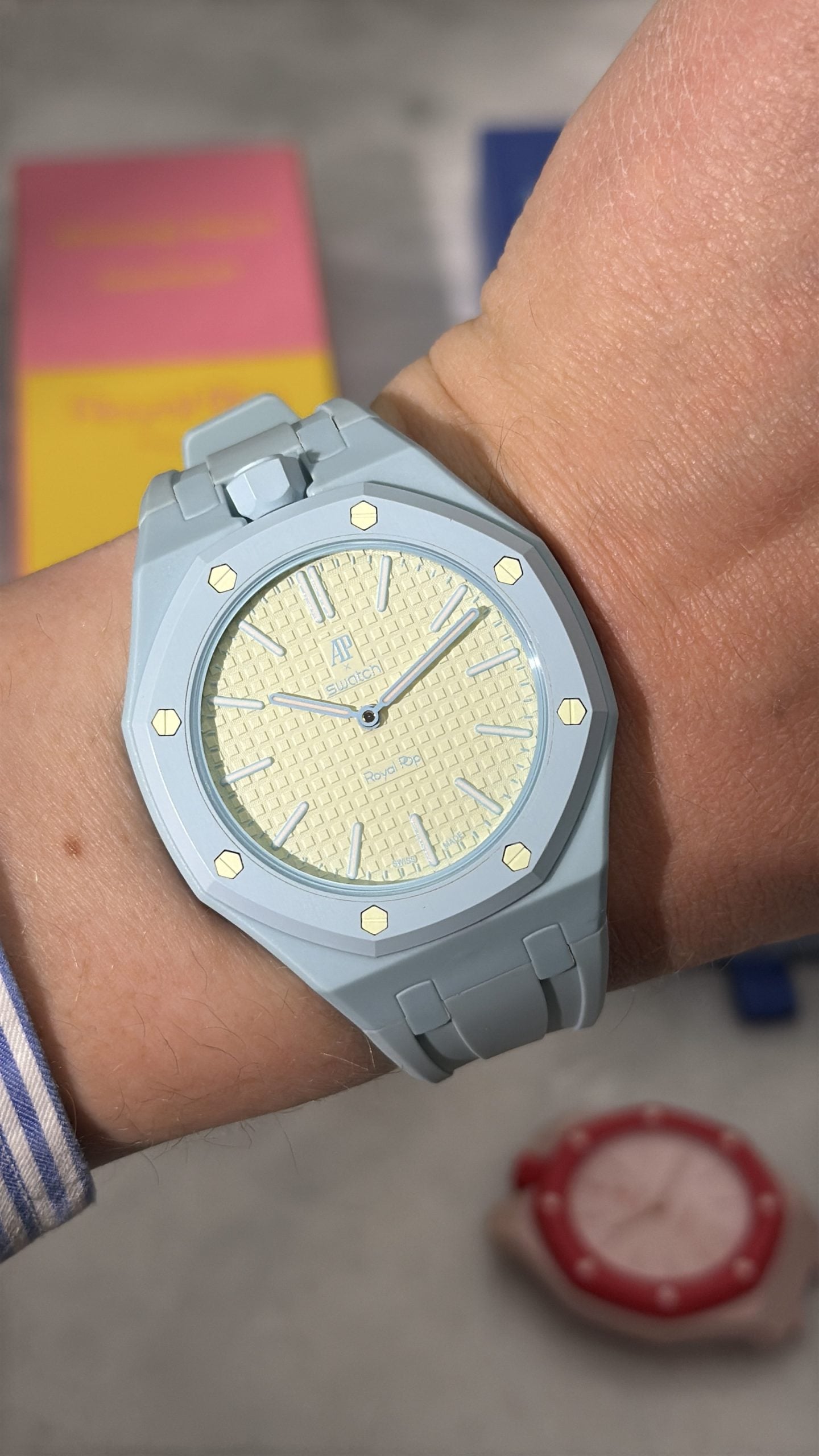 Ap × swatch royal pop blaue acht med ljusblå pastellboett och crèmefärgad tavla, buren på handleden ap × swatch royal pop blaue acht med ljusblå pastellboett och crèmefärgad tavla, buren på handleden