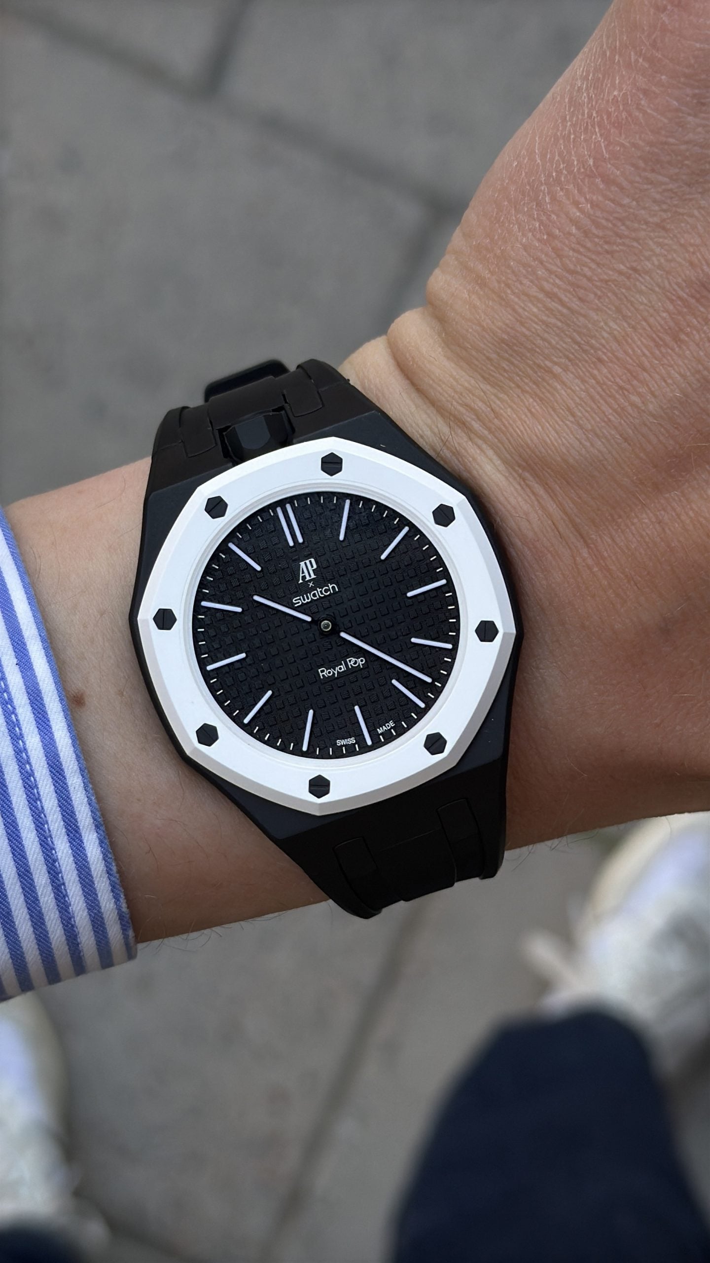 Ap × swatch royal pop ocho negro med svart boett och vit lünett, buren på handleden med svart gummistrap ap × swatch royal pop ocho negro med svart boett och vit lünett, buren på handleden med svart gummistrap