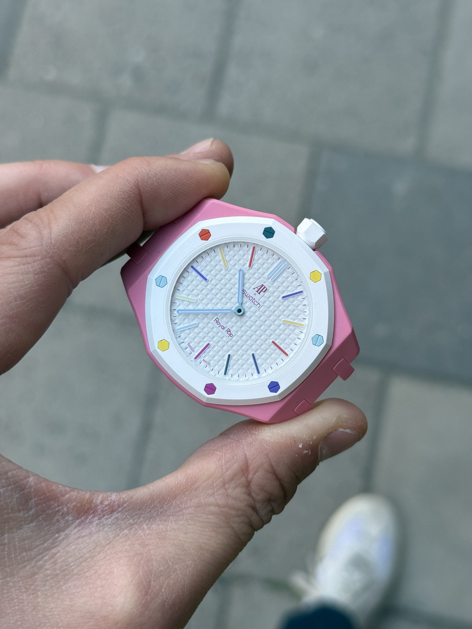 Ap × swatch royal pop otg roz med rosa boett, vit tavla och färgglada regnbågsindex – hands-on i handen ap × swatch royal pop otg roz med rosa boett, vit tavla och färgglada regnbågsindex – hands-on i handen