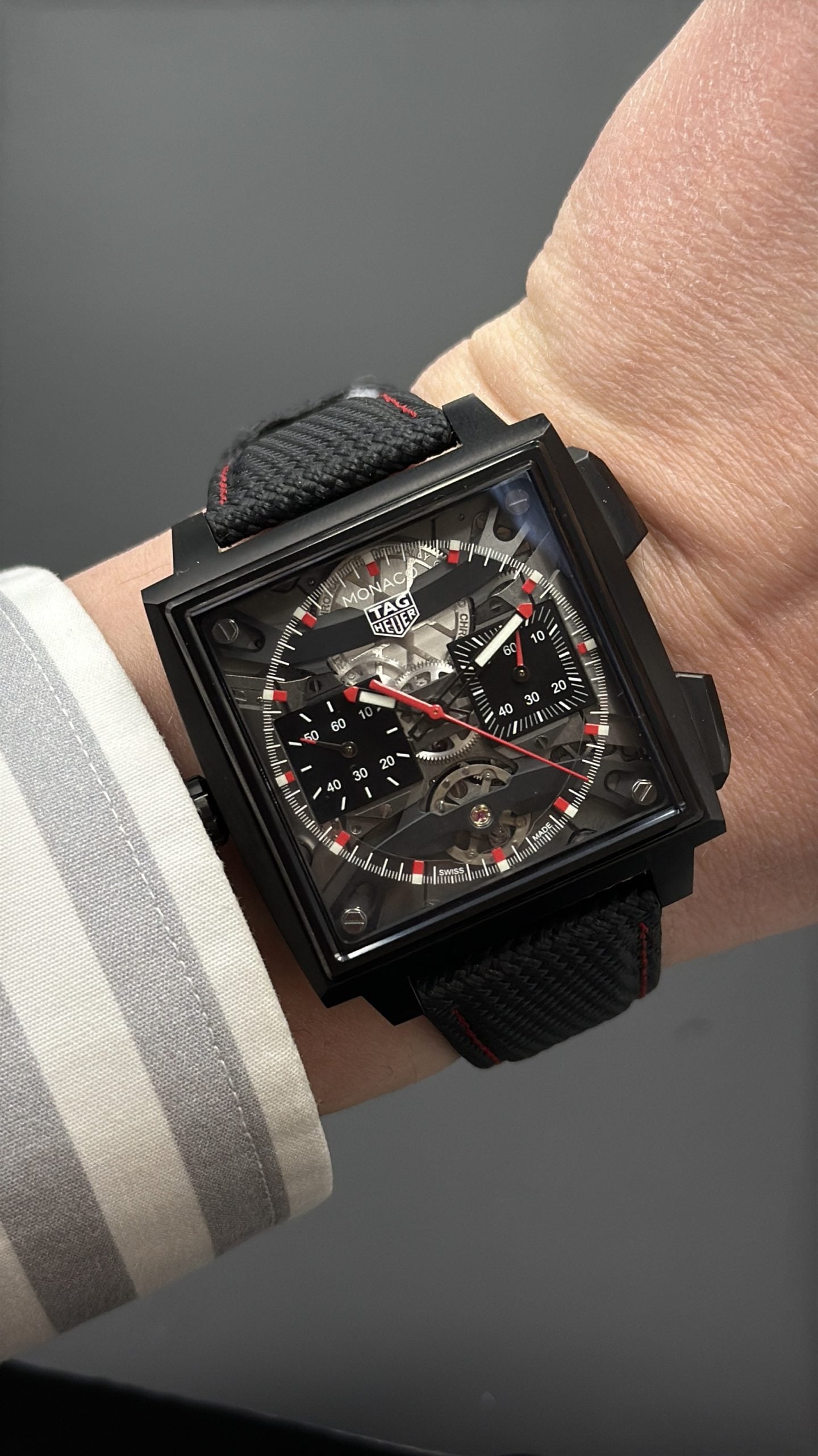 tag heuer monaco skeleton kronograf i svart dlc-kåpa med genombruten tavla, röda accenter och textilrem – hands-on på handleden