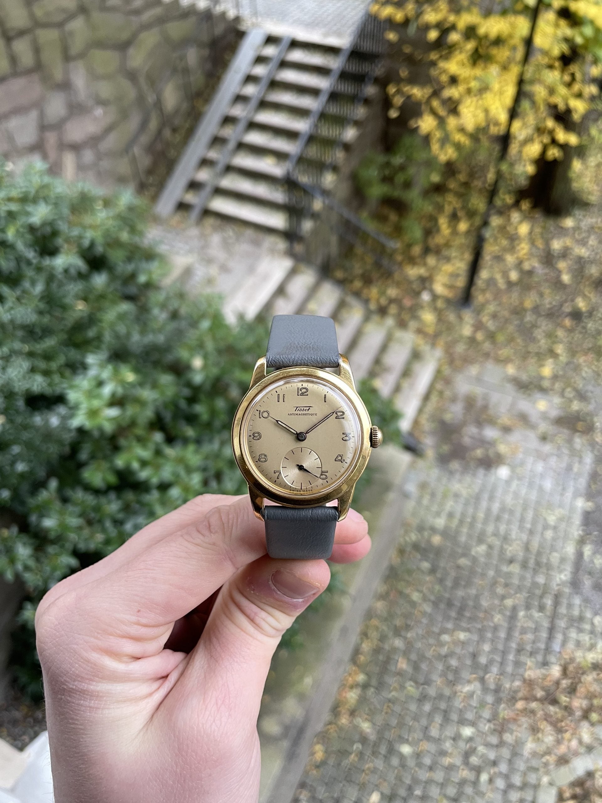 tissot antimagnétique vintage klädklocka i guldton med cremetavla, arabiska siffror och liten sekund på grå läderrem – hands-on