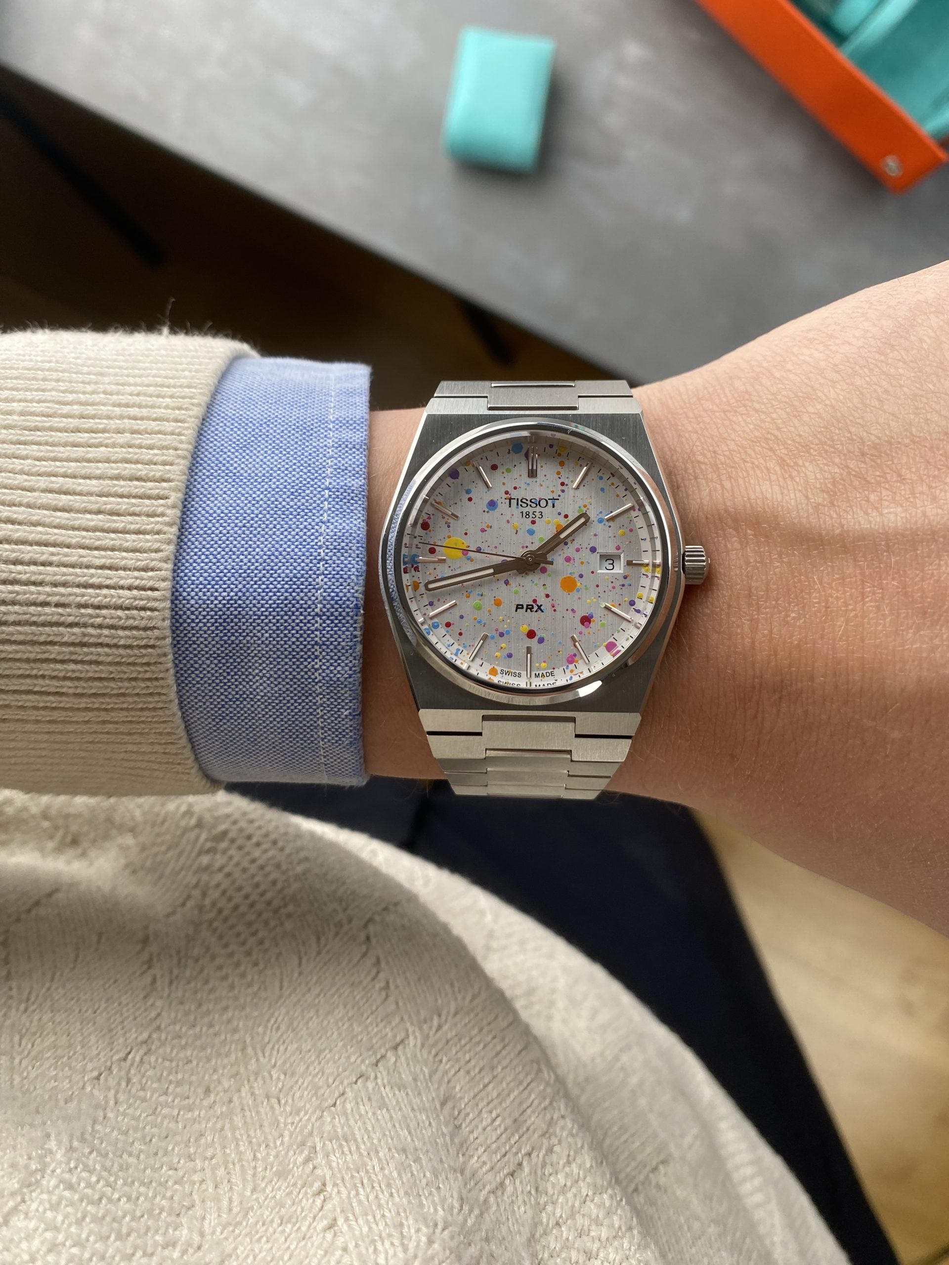 tissot prx med vit tavla i färgglatt stänkmönster, tunn boett och integrerad stållänk – hands-on på handleden