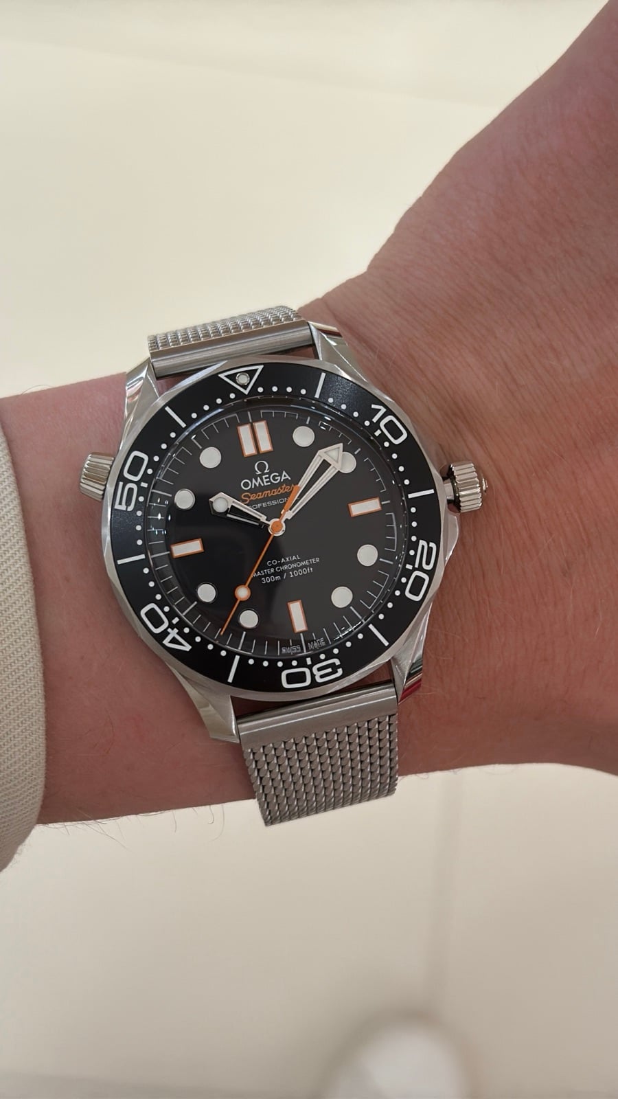 omega seamaster diver 300m utan datum på mesh-länk – svart urtavla med orange detaljer, fotad på handleden