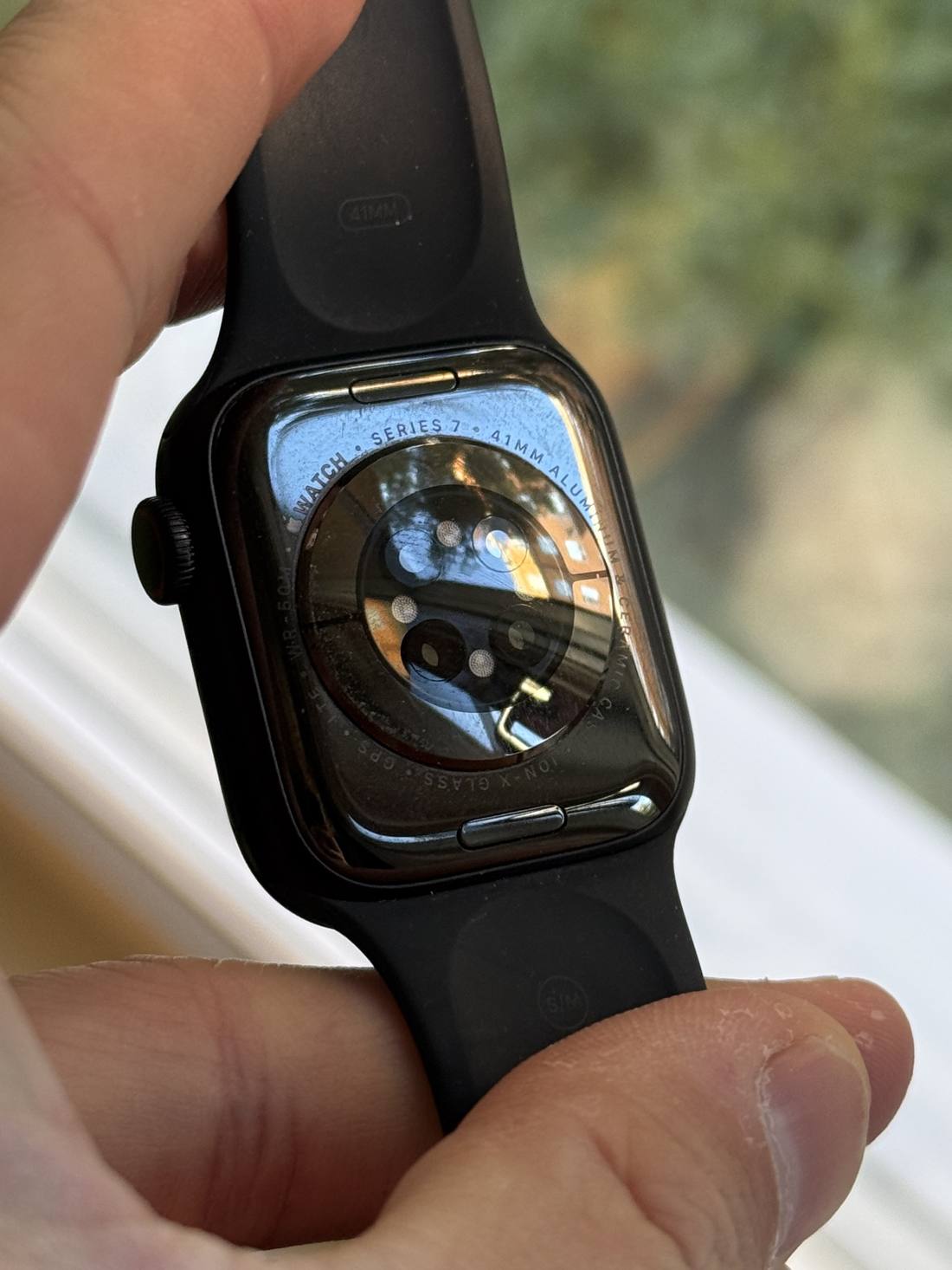 baksidan på en apple watch där gravyren watch series 7 41mm aluminium syns tydligt runt sensorpaketet
