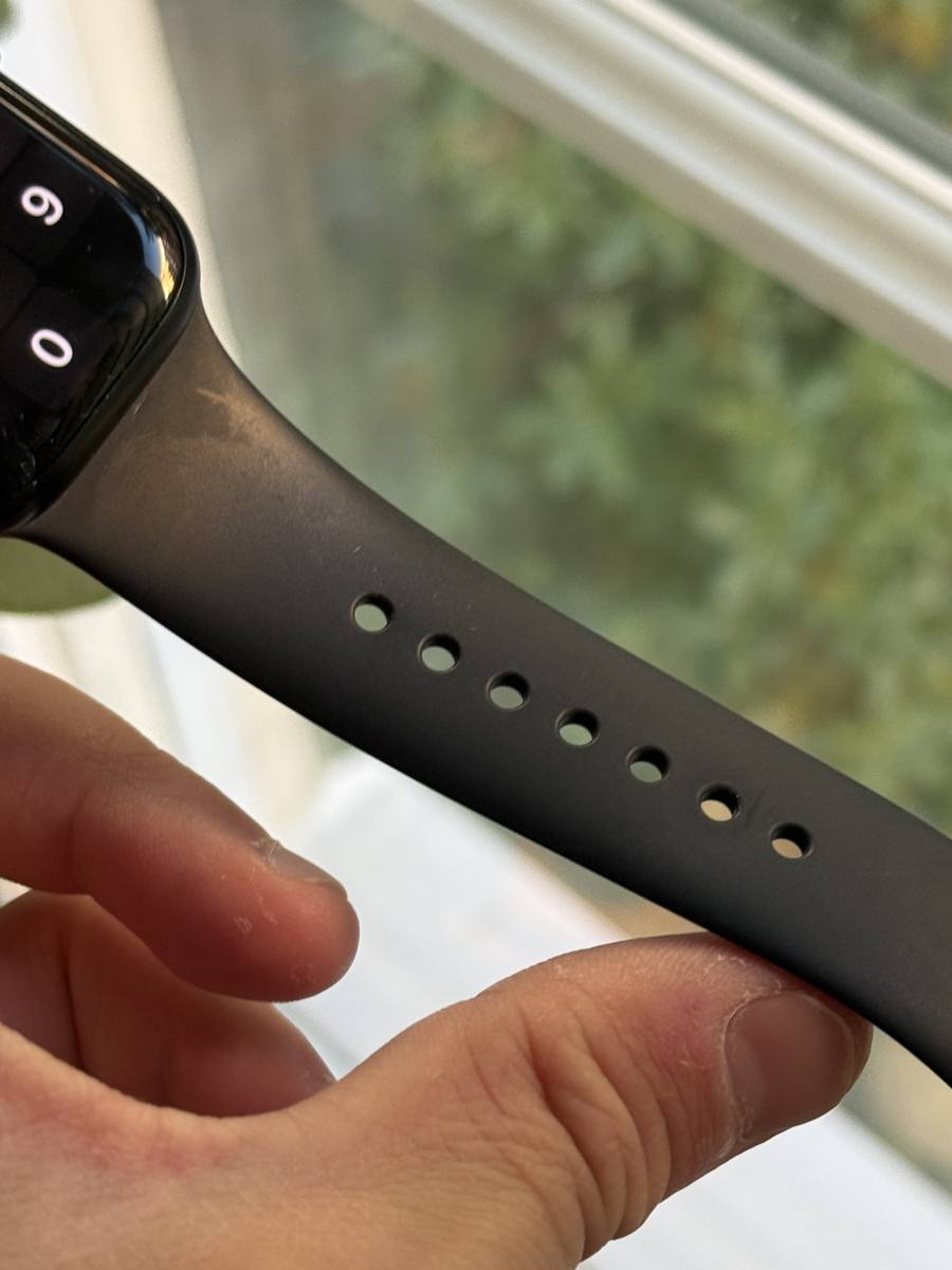 närbild på de sju justeringshålen längs ett svart sportband till apple watch