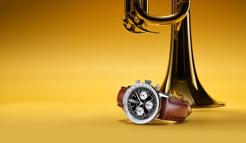breitling navitimer b09 chronograph 41 tribute to miles davis med svart reverse panda-urtavla på brunt läderband, lutad mot en mässingstrumpet