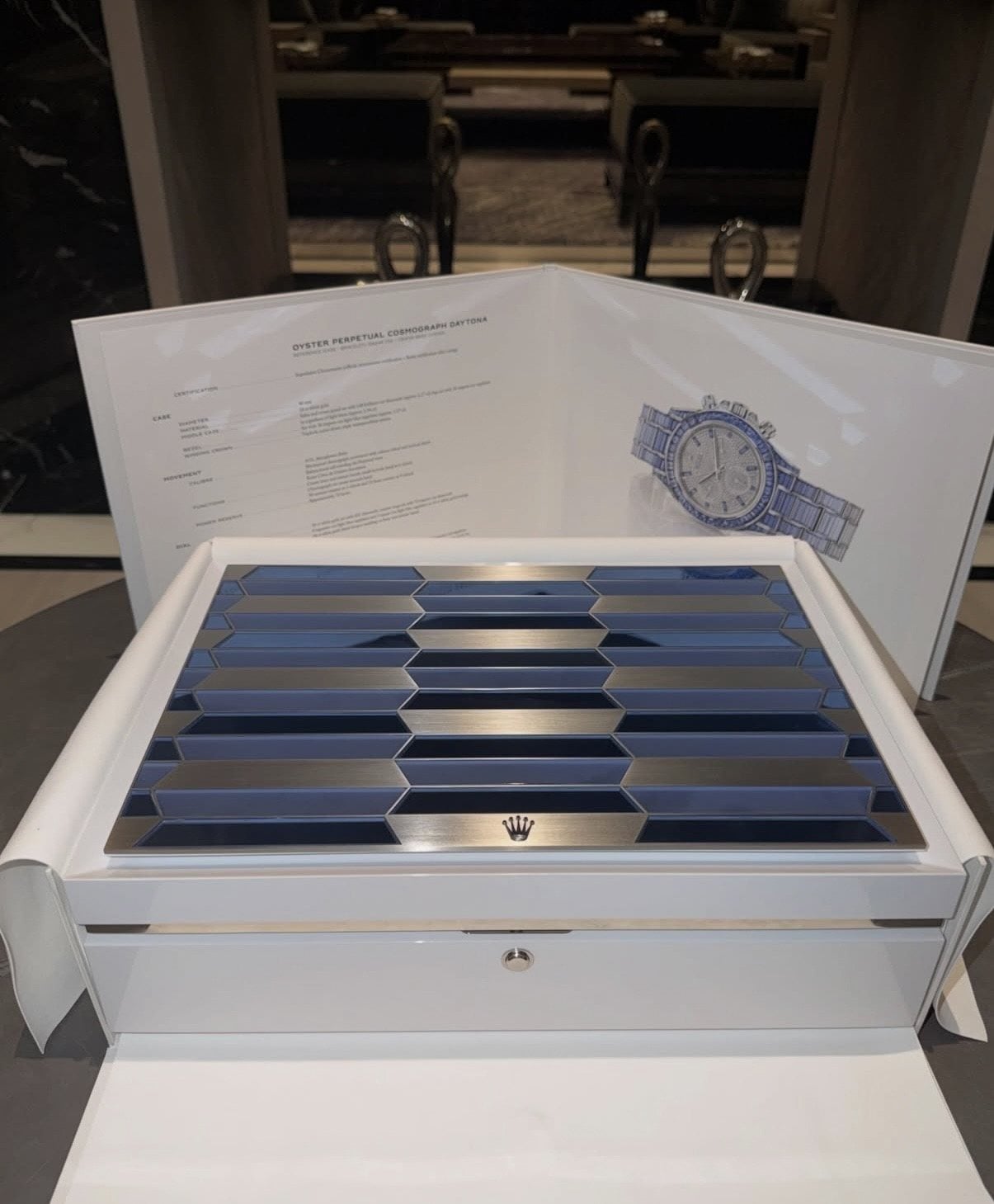 rolex specifikationsblad för oyster perpetual cosmograph daytona bredvid den vita presentationsasken