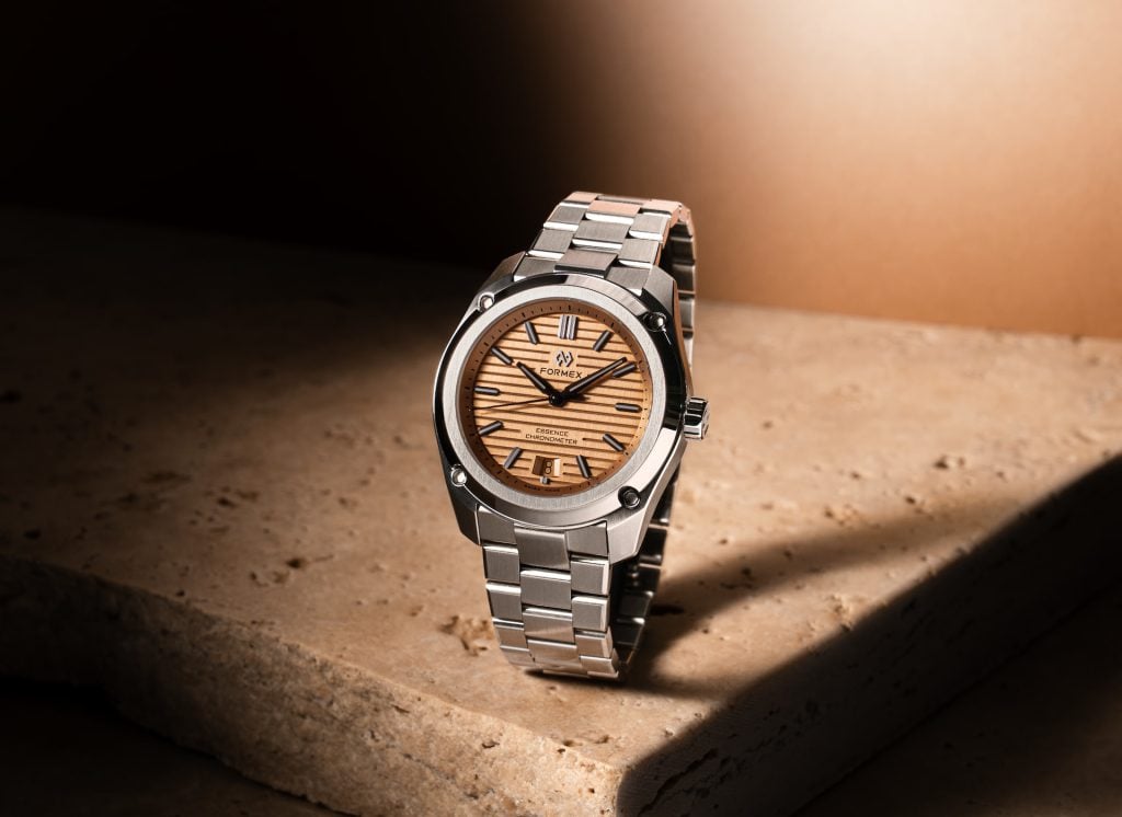 formex essence 39 mm med radiant bronze-urtavla på stållänk, fotograferad på en travertinsten i varmt sidoljus