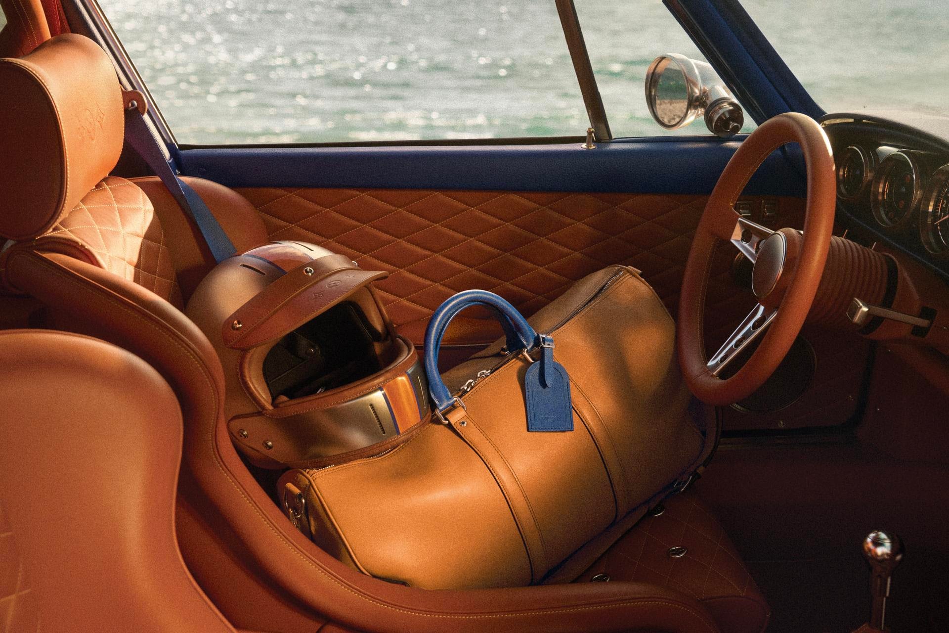 interiören i louis vuitton x singer porsche 911 med rutstickat konjaksfärgat läder, hjälm och keepall i passagerarsätet