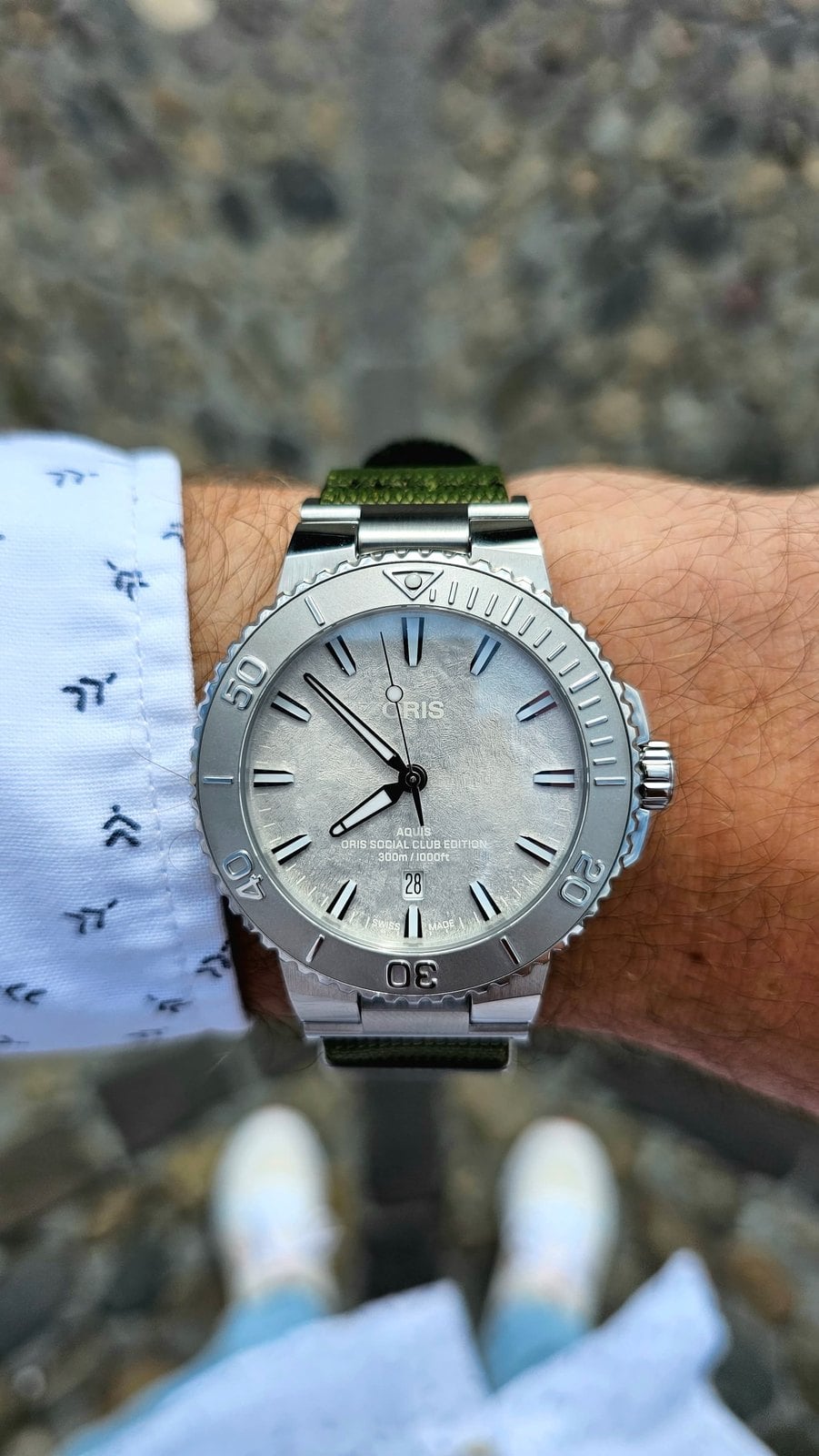 oris social club edition ii på handleden med frostad silverurtavla och olivgrönt nato-armband