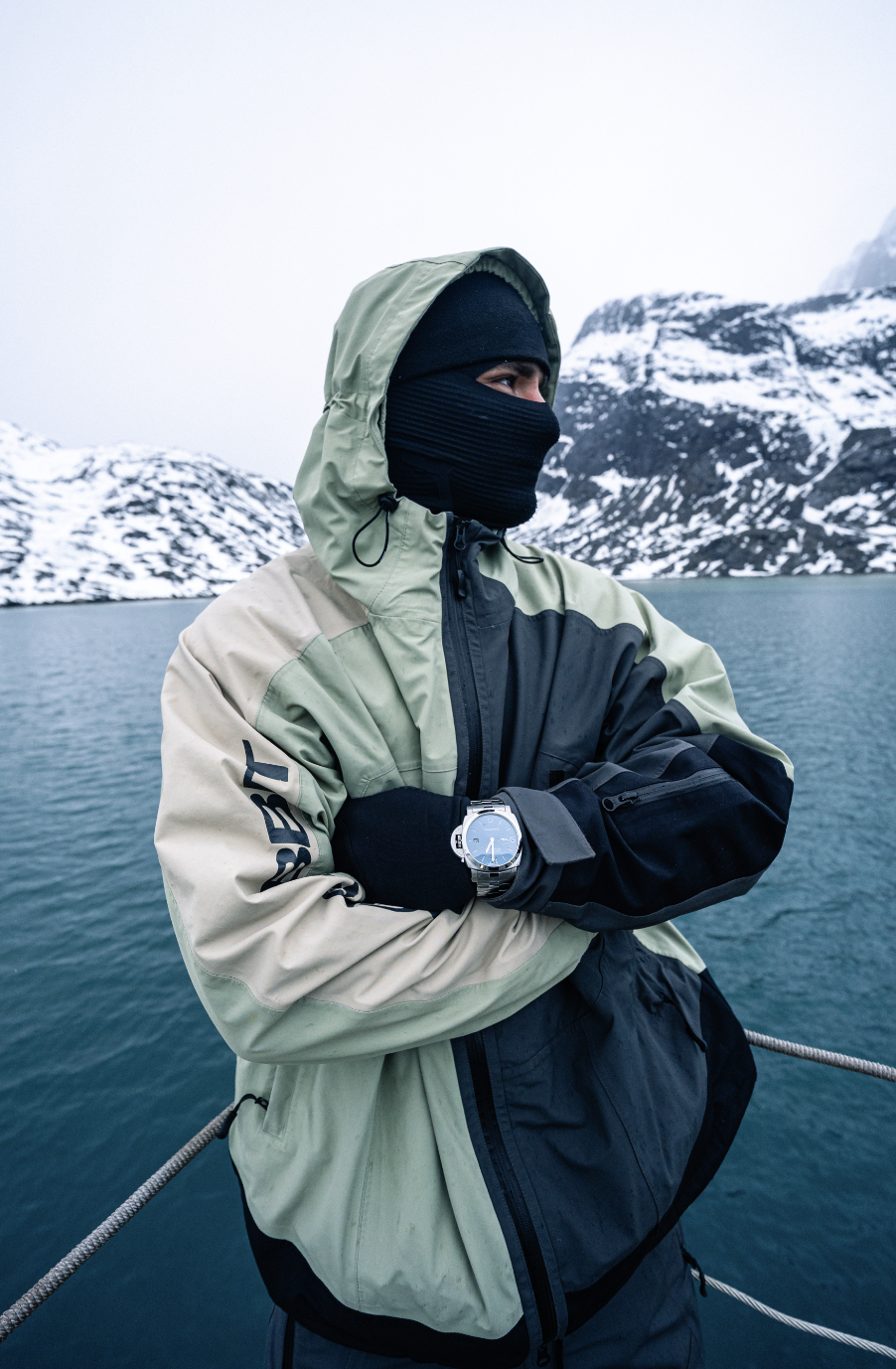 Côme girardot med korsade armar vid en fjord, panerai-klockan synlig över handsken côme girardot med korsade armar vid en fjord, panerai-klockan synlig över handsken
