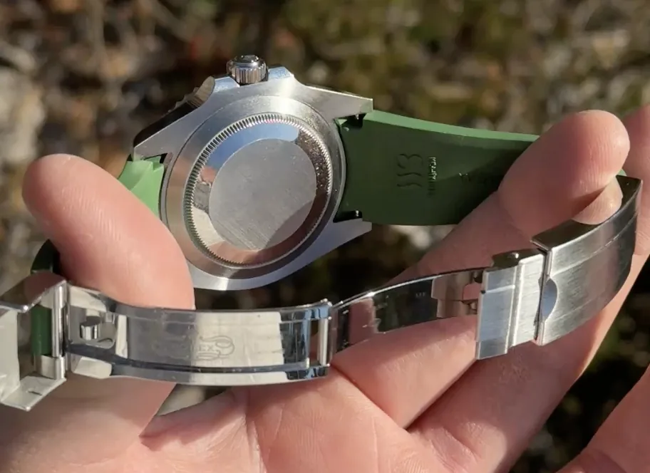 närbild på kurvad ändlänk där gummiarmbandet möter boetten på en rolex submariner
