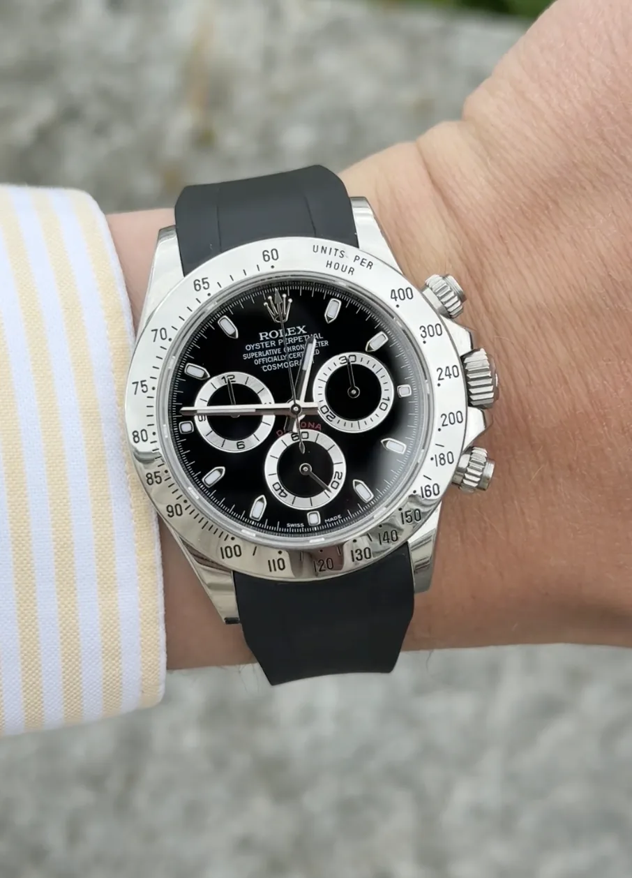rolex daytona i stål med svart gummiarmband buren på handled