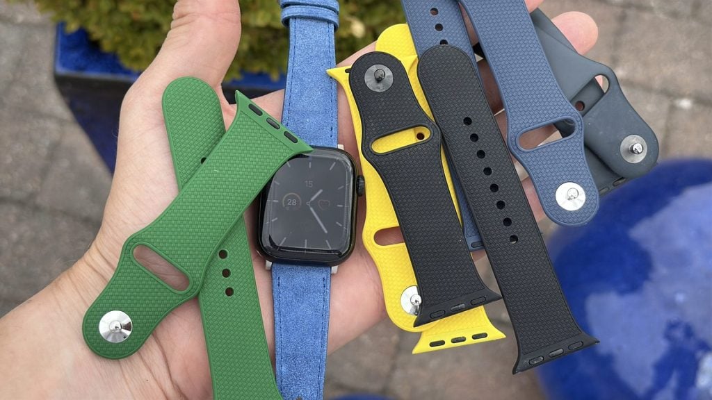 sex wristbuddys-armband till apple watch i handen tillsammans med en apple watch series 7 i 41 mm