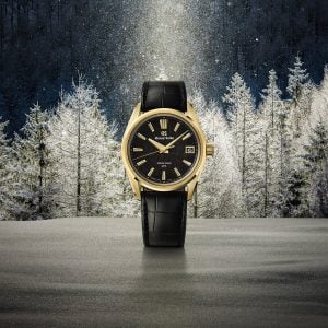 grand seiko spring drive u.f.a. ice forest at dawn i 18k gult guld mot en snötäckt lärkskog i gryningsljus