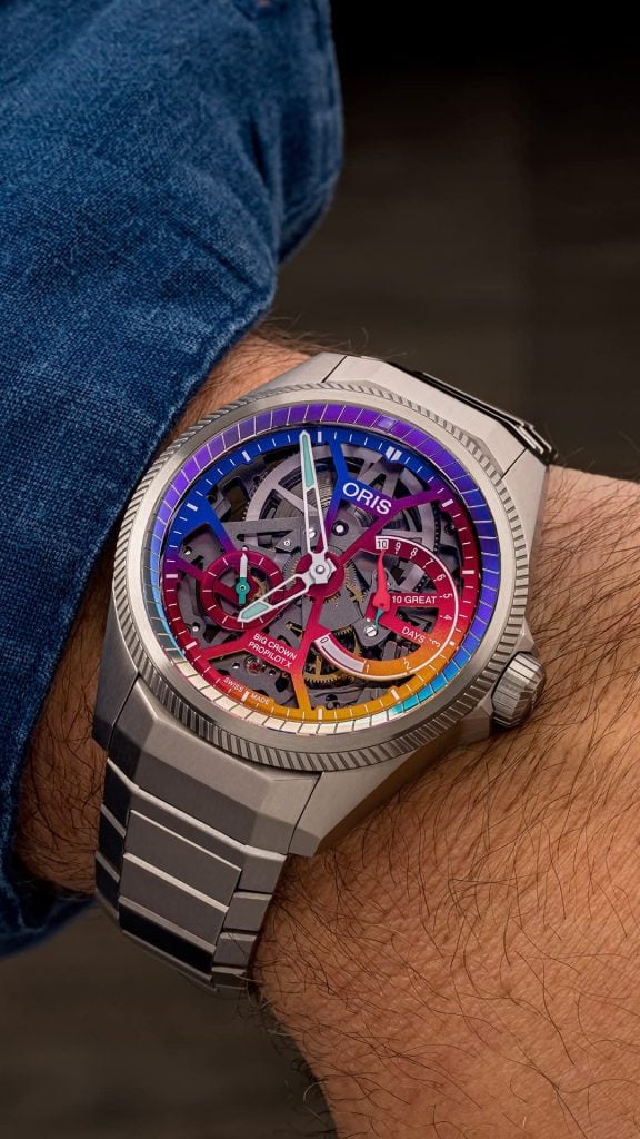 Oris propilot x gonzo edition på handleden på titanarmband inomhus, där urtavelringen läser lila och blå oris propilot x gonzo edition på handleden på titanarmband inomhus, där urtavelringen läser lila och blå