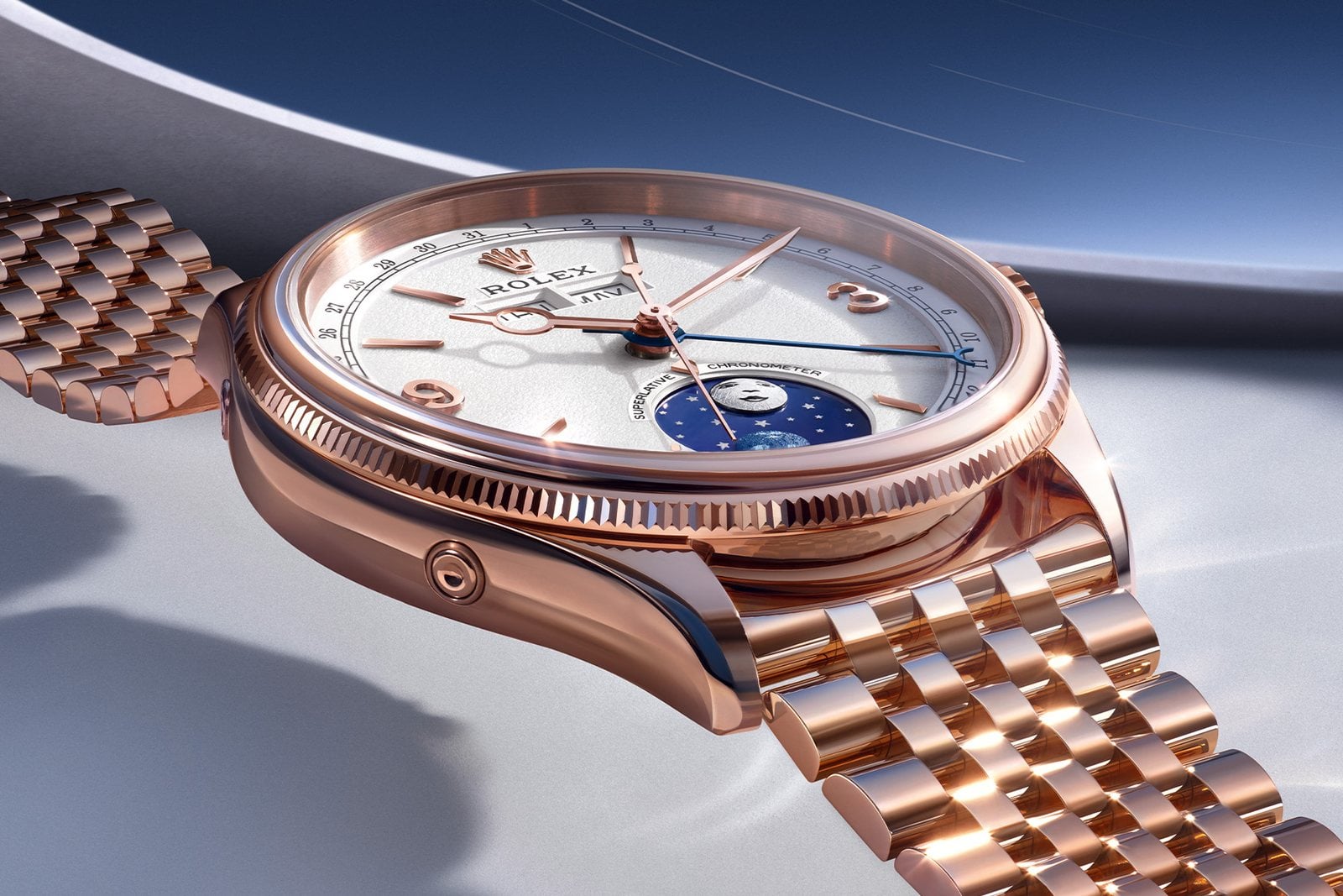 närbild på urtavlan och settimo-armbandet på rolex perpetual padellone i everose-guld, med datumskala på flängen och blå datumvisare