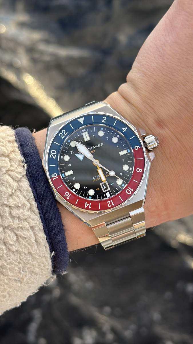 spinnaker dumas gmt automatic sedd snett uppifrån på handleden där den åttkantiga stålboetten och bezelns färgdelning syns