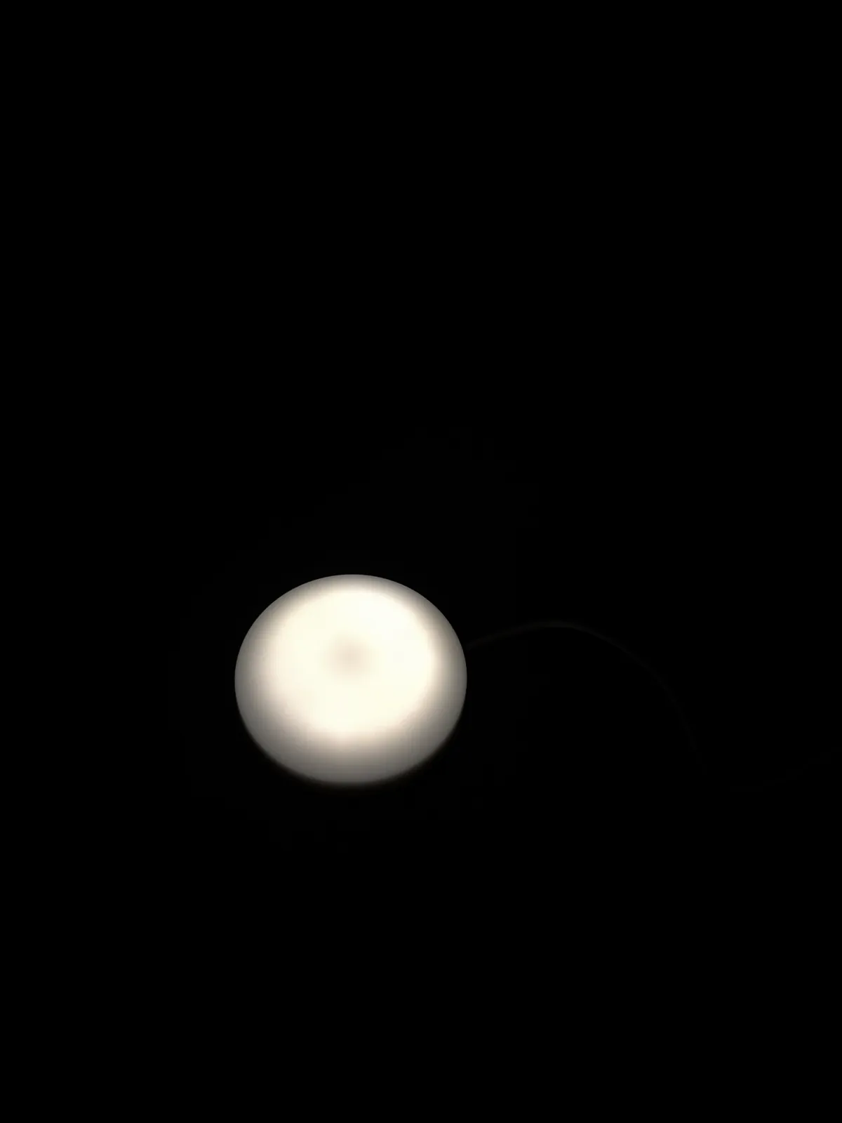 Wakeme wake-up light som lyser i ett helt mörkt sovrum, sett ovanifrån wakeme wake-up light som lyser i ett helt mörkt sovrum, sett ovanifrån