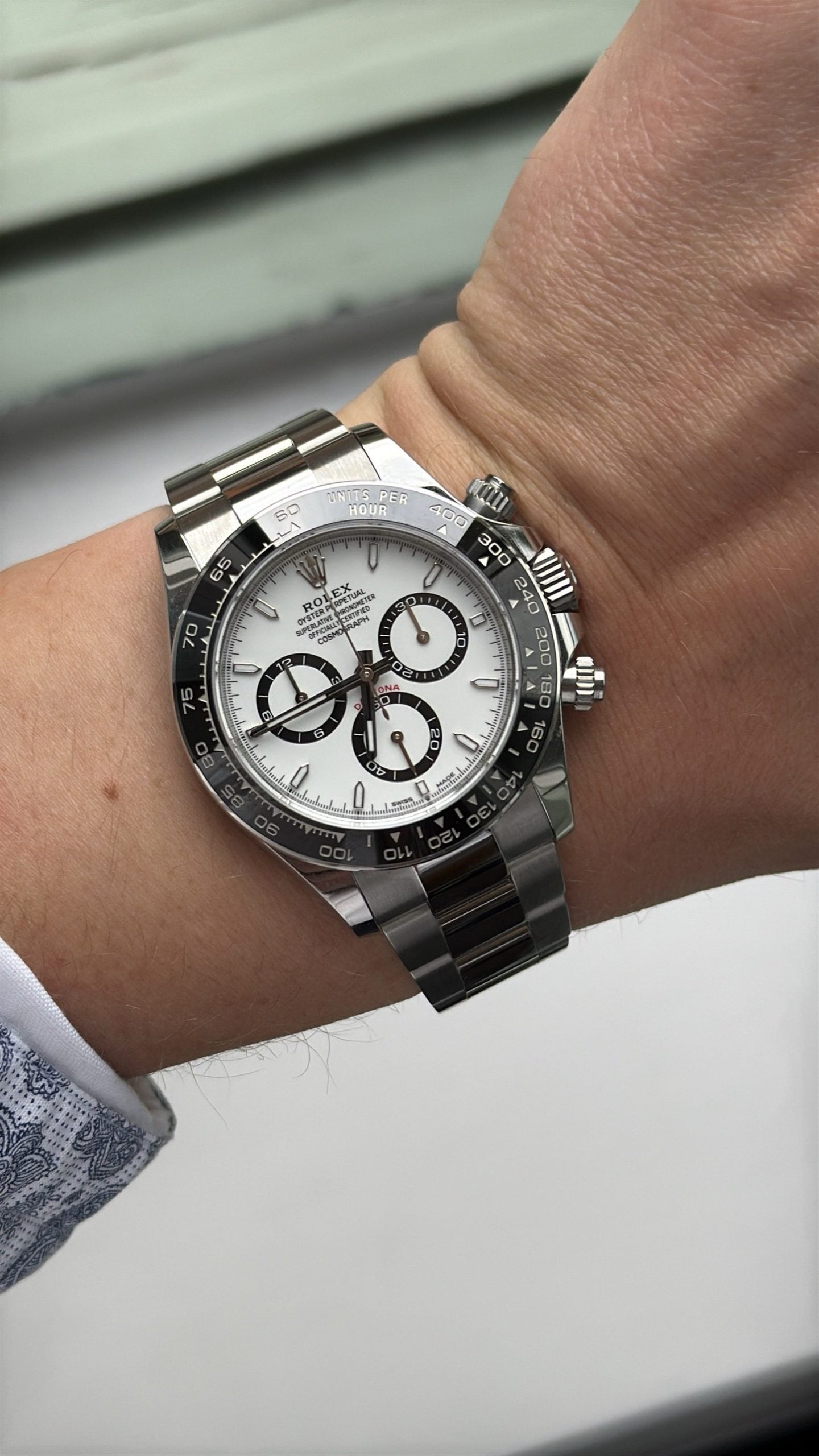 Rolex cosmograph daytona i stål med vit urtavla och svart keramikram på handleden rolex cosmograph daytona i stål med vit urtavla och svart keramikram på handleden
